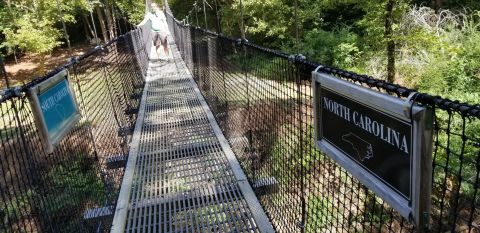 Walk Across The Carolinas Border On A Daring 180-Foot Suspension Bridge On The Carolina Thread Trail In North Carolina