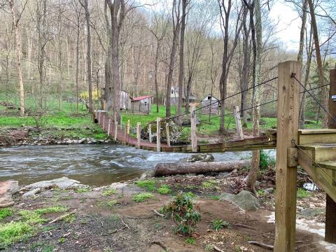 Walk Across A Suspension Bridge To Reach This Whimsical Maryland Cabin On The Creek