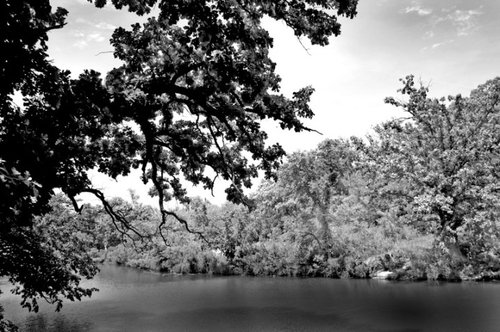 A greyscale photo of the waters near the waterfall.