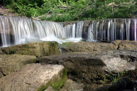 A more distant view from water level of one of the short waterfall with smooth, long exposure photography.