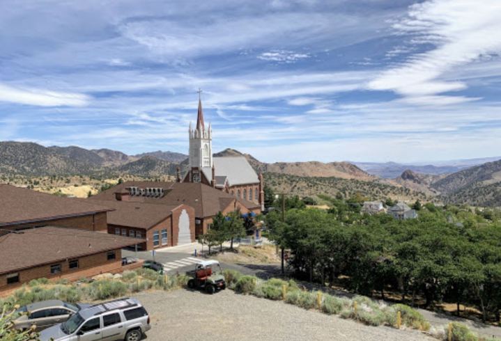 An aerial downtown view of Virginia City, Nevada with a church in the foreground and desert scenery in the background