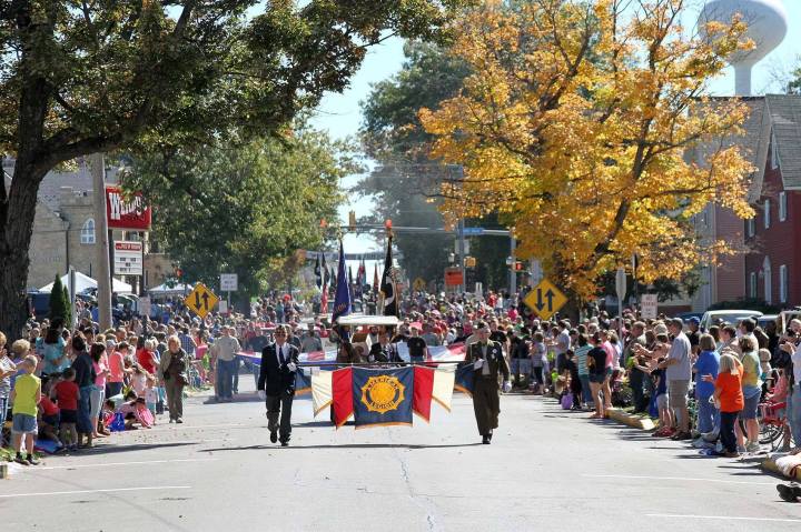 A crowded street filled with people watching a parade.