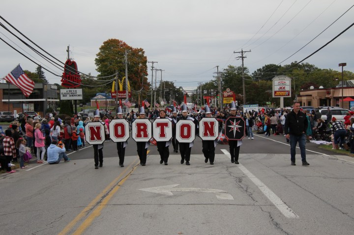 A parade marches down a crowded street