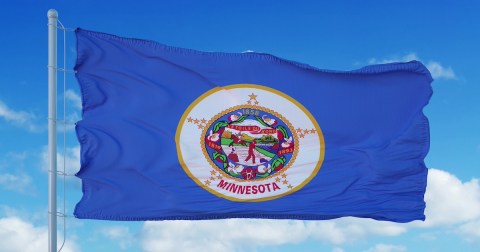 Minnesota flag on a flagpole waving in the wind, blue sky background. 3d rendering.