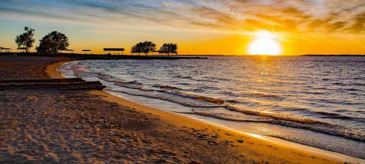 Lakeshore and sand at sunset at Ray Roberts Lake State Park, one of the best state parks in Texas based on visitor totals.