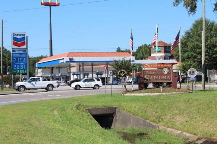 Street view of the exterior of Satsuma Chevron BBQ, a popular gas station restaurant in Alabama