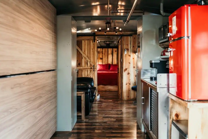 Interior of the Bourbon Trail Airbnb with a queen bed, couch, and kitchenette.